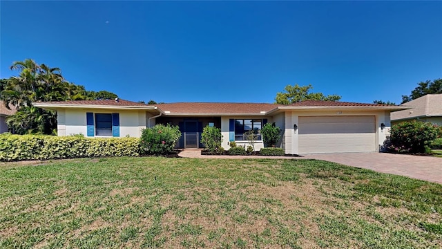 ranch-style house featuring a garage and a front lawn