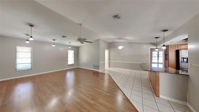 interior space with plenty of natural light, light hardwood / wood-style floors, ceiling fan, and vaulted ceiling