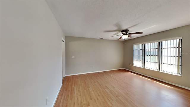 spare room featuring ceiling fan, a textured ceiling, and light hardwood / wood-style flooring