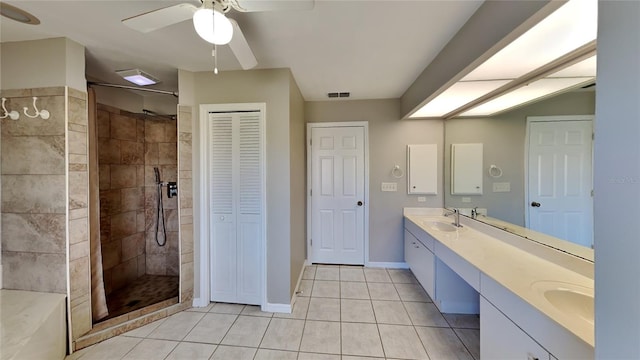 bathroom with a tile shower, ceiling fan, tile patterned flooring, and vanity