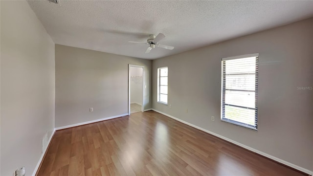 unfurnished room with hardwood / wood-style flooring, ceiling fan, and a textured ceiling