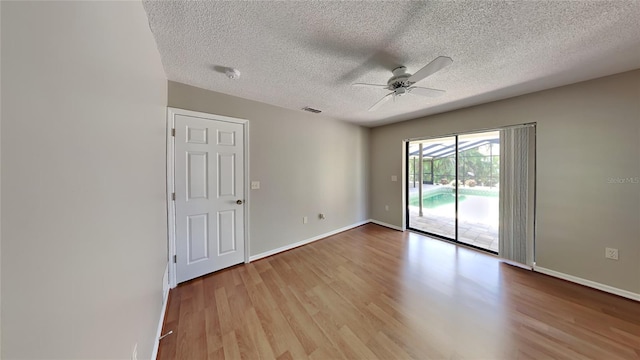 empty room featuring ceiling fan, light hardwood / wood-style floors, and a textured ceiling