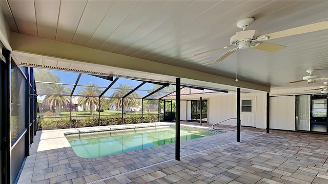 view of pool with glass enclosure, ceiling fan, and a patio area