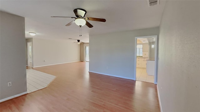 empty room with visible vents, plenty of natural light, ceiling fan, and wood finished floors