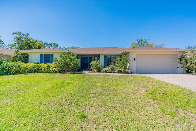 ranch-style home featuring a front lawn, an attached garage, driveway, and stucco siding