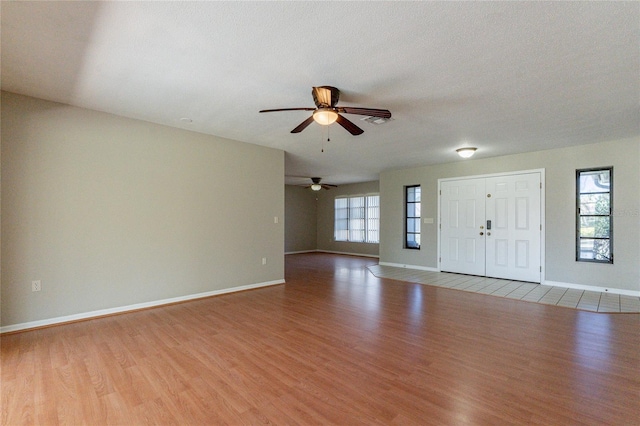 entrance foyer featuring a textured ceiling, wood finished floors, baseboards, and ceiling fan