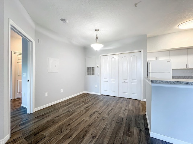 interior space featuring a textured ceiling and dark wood-type flooring