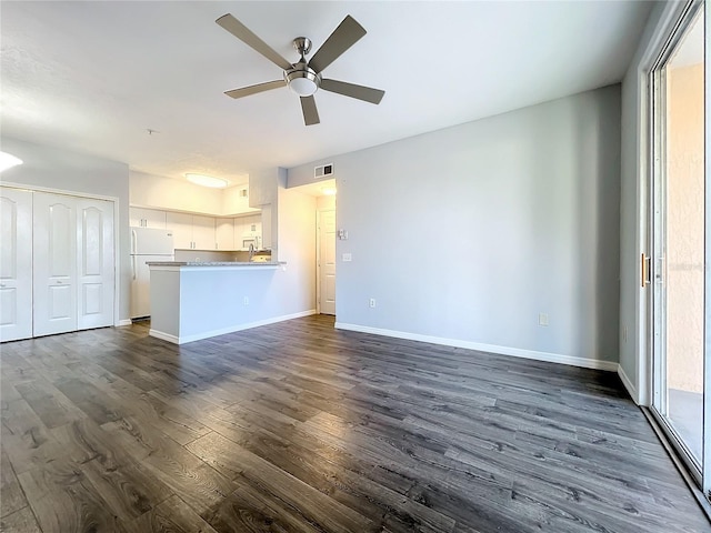 unfurnished living room featuring ceiling fan and dark hardwood / wood-style floors