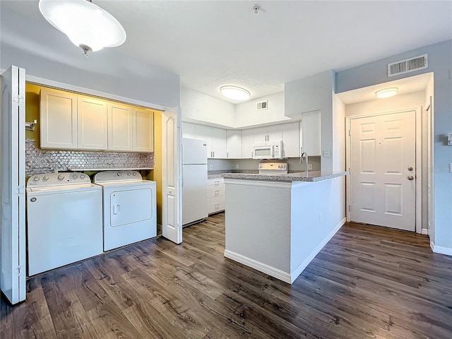 kitchen featuring white cabinets, white appliances, washer and dryer, and dark hardwood / wood-style flooring