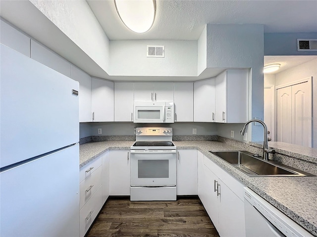 kitchen featuring white appliances, white cabinetry, and sink