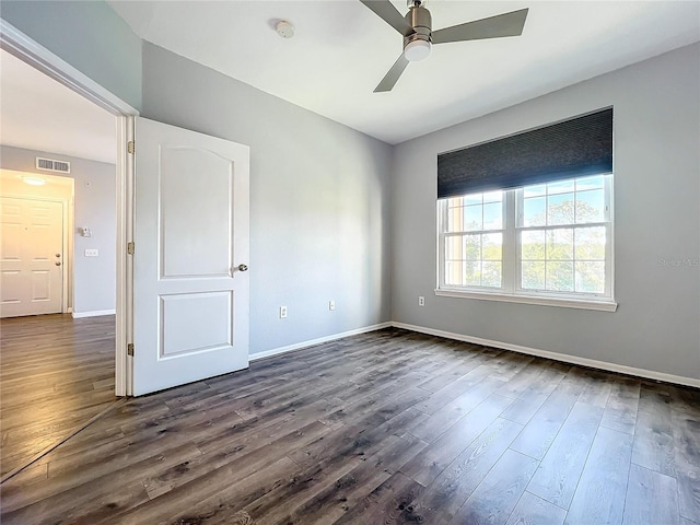 spare room featuring ceiling fan and dark wood-type flooring