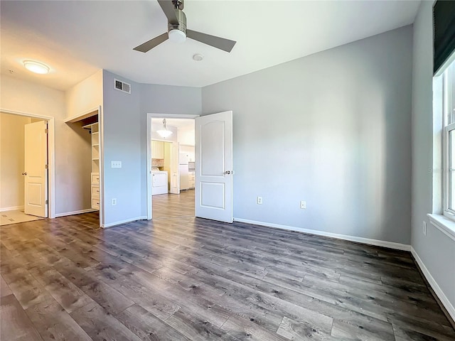 unfurnished bedroom with multiple windows, dark hardwood / wood-style flooring, ceiling fan, and a closet