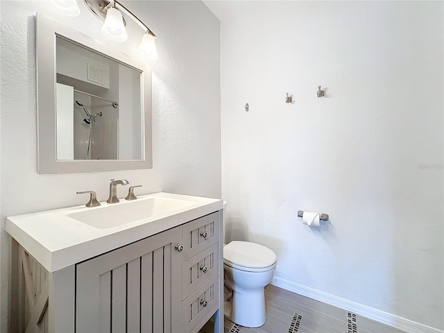 bathroom featuring walk in shower, vanity, toilet, and hardwood / wood-style flooring