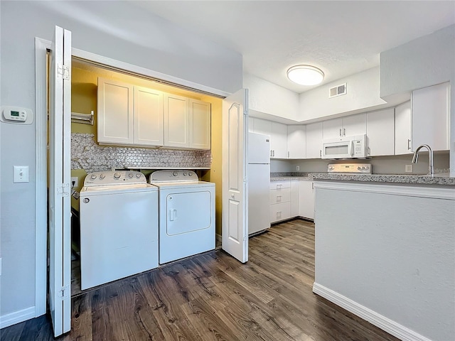 clothes washing area with cabinets, sink, independent washer and dryer, and dark hardwood / wood-style flooring