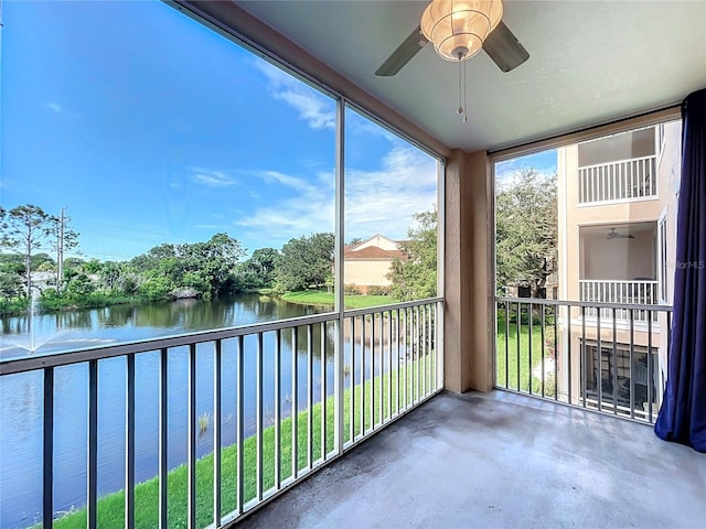 unfurnished sunroom featuring ceiling fan and a water view