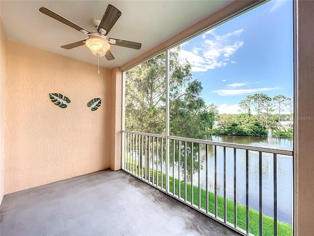 balcony featuring a water view and ceiling fan