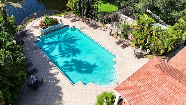 view of swimming pool featuring a patio and a water view