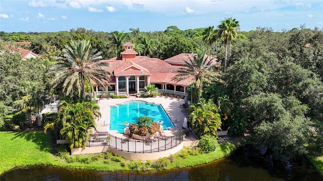 view of swimming pool with a lawn, a water view, and a patio area