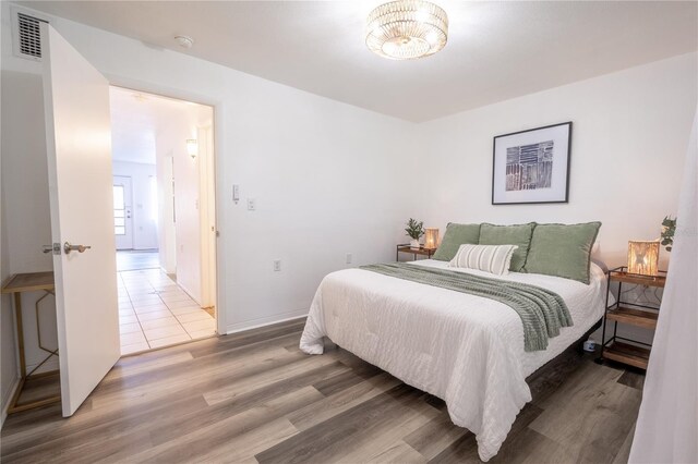 bedroom with hardwood / wood-style flooring and a chandelier