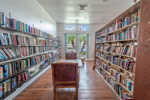 interior space with a paneled ceiling and hardwood / wood-style floors