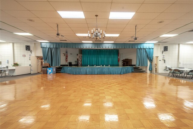 miscellaneous room with a paneled ceiling and a chandelier