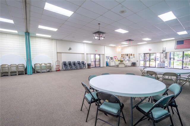 carpeted dining space featuring a paneled ceiling