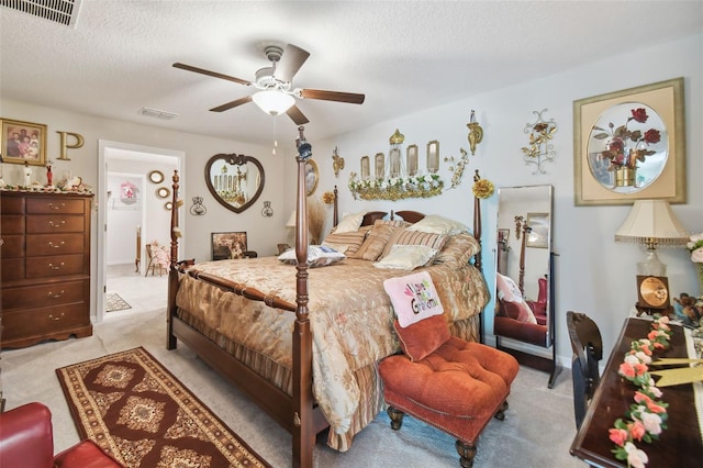 bedroom featuring a textured ceiling, ceiling fan, and light carpet