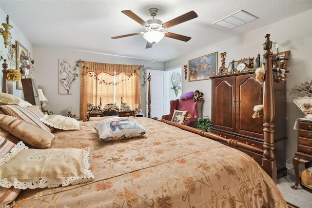 carpeted bedroom with ceiling fan and a textured ceiling