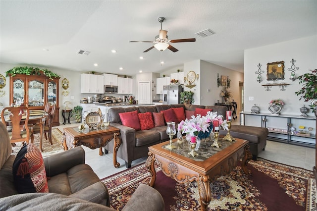 living room with a textured ceiling, ceiling fan, and tile patterned floors