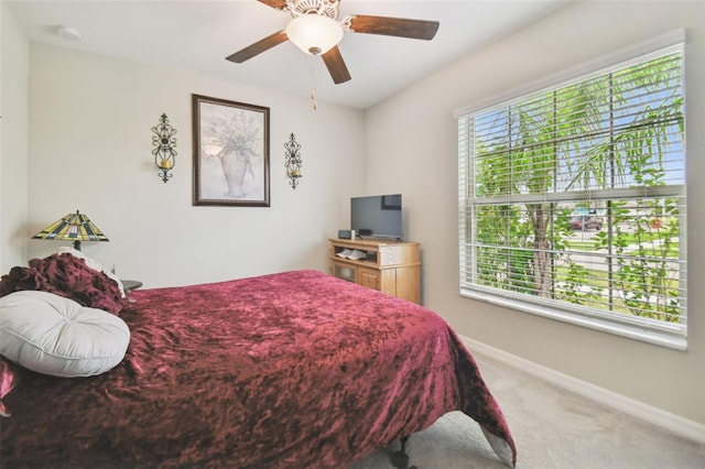 bedroom with carpet, ceiling fan, and multiple windows