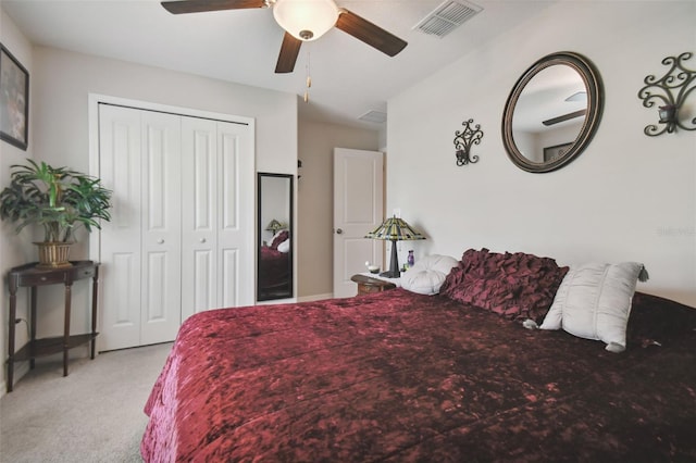 bedroom with light colored carpet, ceiling fan, and a closet