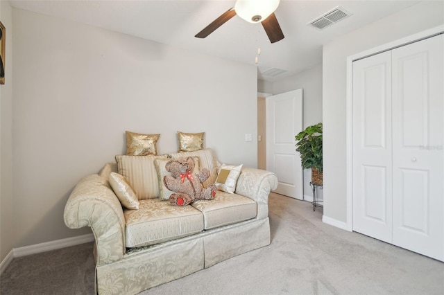 living area with light carpet and ceiling fan