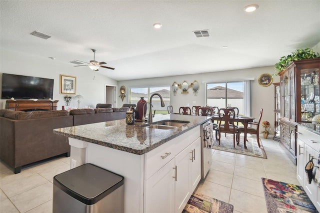 kitchen with vaulted ceiling, a center island with sink, sink, ceiling fan, and white cabinets