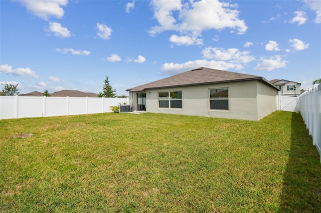 back of house with a lawn and central AC unit