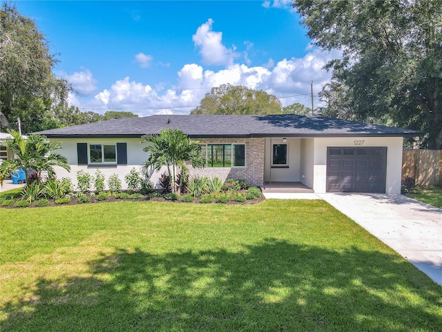 single story home with a garage and a front lawn