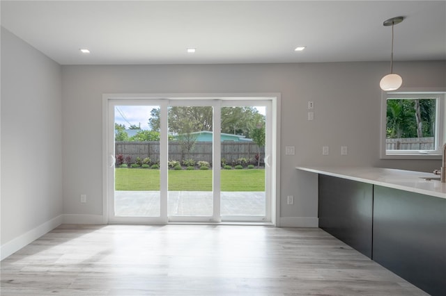 unfurnished dining area with light hardwood / wood-style flooring and sink