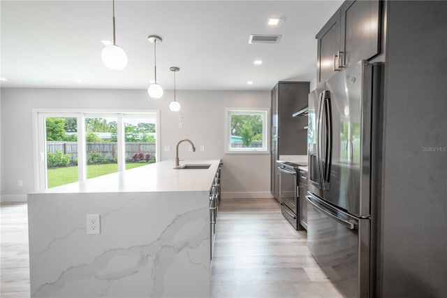 kitchen featuring sink, pendant lighting, stainless steel appliances, and plenty of natural light