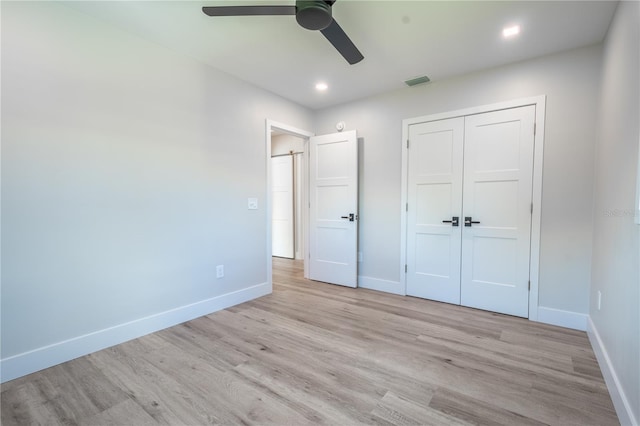 unfurnished bedroom featuring ceiling fan, light hardwood / wood-style flooring, and a closet