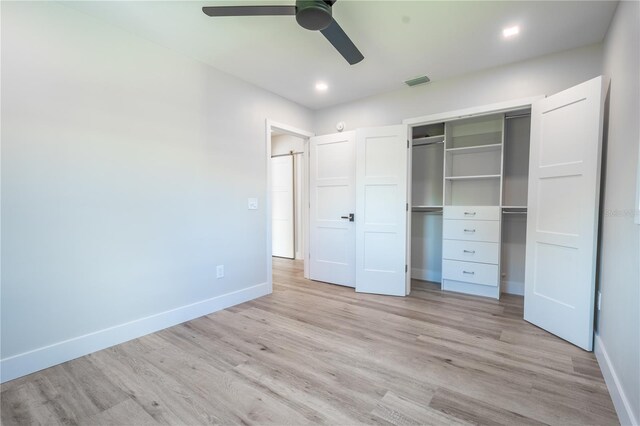 unfurnished bedroom featuring ceiling fan, light hardwood / wood-style flooring, and a closet