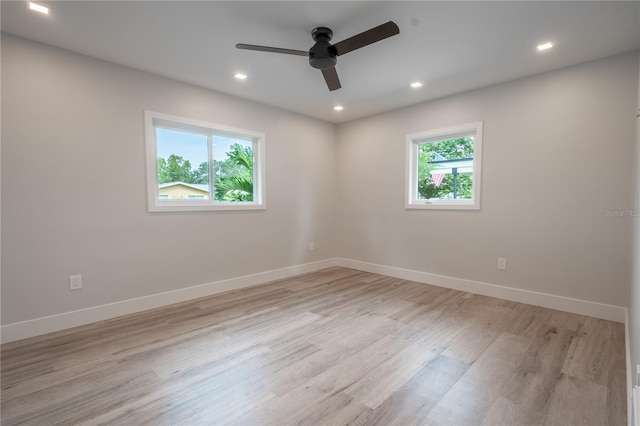 spare room featuring light hardwood / wood-style floors, ceiling fan, and a wealth of natural light