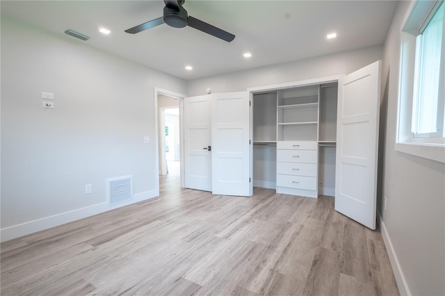 unfurnished bedroom with a closet, light wood-type flooring, multiple windows, and ceiling fan