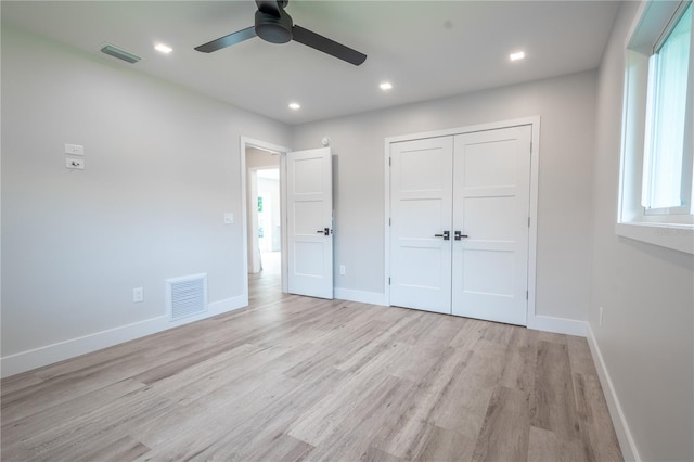 unfurnished bedroom featuring light wood-type flooring, ceiling fan, and a closet