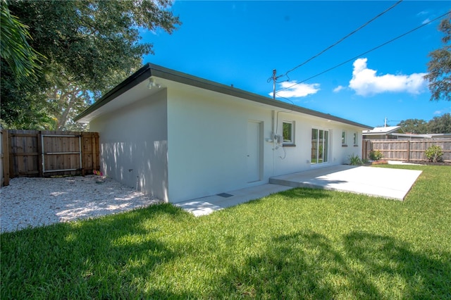 rear view of house featuring a patio and a yard