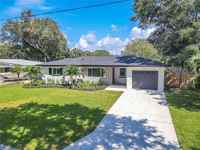 ranch-style house featuring a front yard and a garage