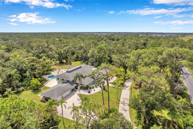 drone / aerial view featuring a wooded view