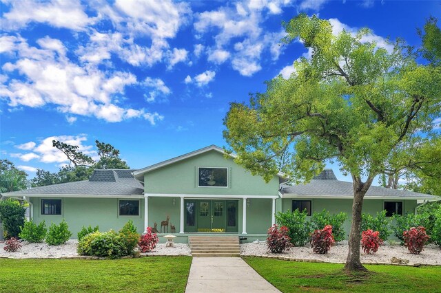 view of front of home featuring covered porch and a front lawn