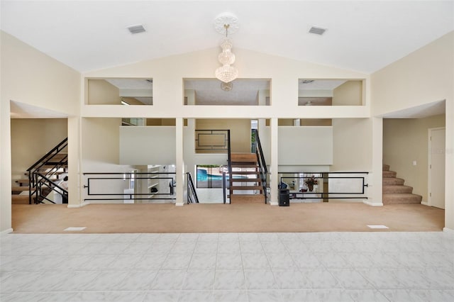 carpeted spare room featuring visible vents, high vaulted ceiling, and stairway