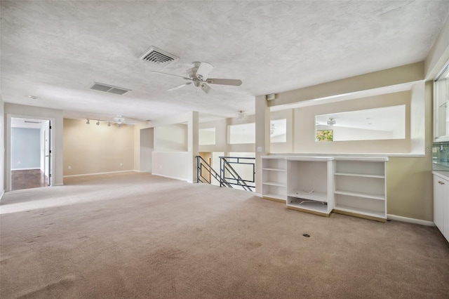 carpeted empty room with a textured ceiling and ceiling fan