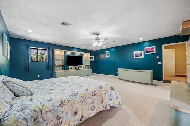 carpeted bedroom featuring a textured ceiling and ceiling fan