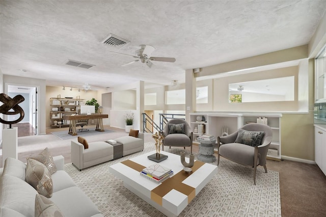 living room featuring light carpet, a textured ceiling, and ceiling fan